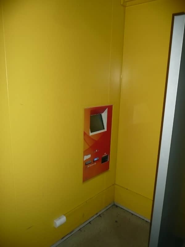 W ścianie koloru żółtego zamontowane urządzenie przypominające bankomat, które kredytowało i wypłacało wygrane graczom.